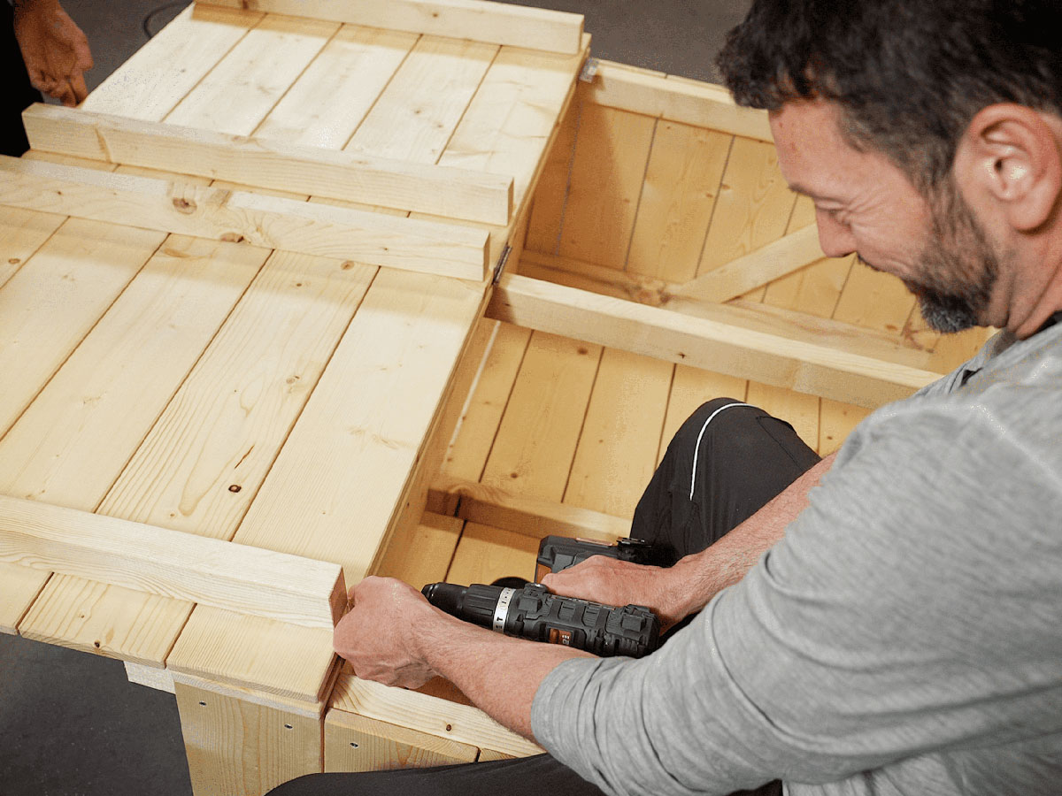Klappe konstruieren: Die restlichen fünf Bretter mit vier Balken verschrauben, um eine Klappe zu bauen.