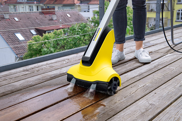 Ein Terrassenreiniger mit rotierenden Bürstenwalzen und kontinuierlicher Wasserzufuhr ermöglicht die schonende Reinigung von Holzoberflächen.