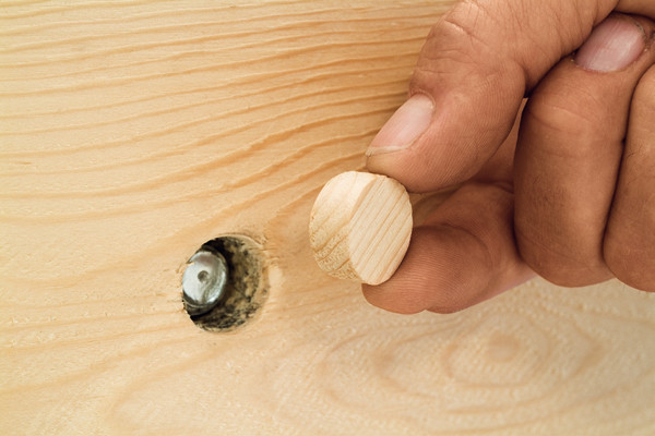 Die Löcher werden mit Querholzplättchen abgedeckt; die Verstärkungen verschwinden im Trägerwerk
