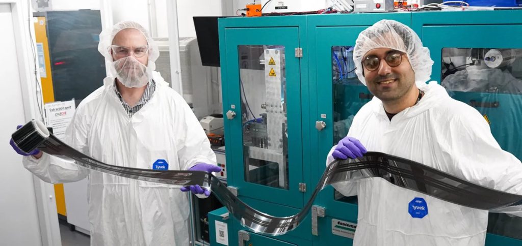 Dr. David Beynon (links) und Dr. Ershad Parvazian (rechts) präsentieren ein Muster der neu entwickelten, vollständig im Rolle-zu-Rolle-Verfahren beschichteten Solarzelle.